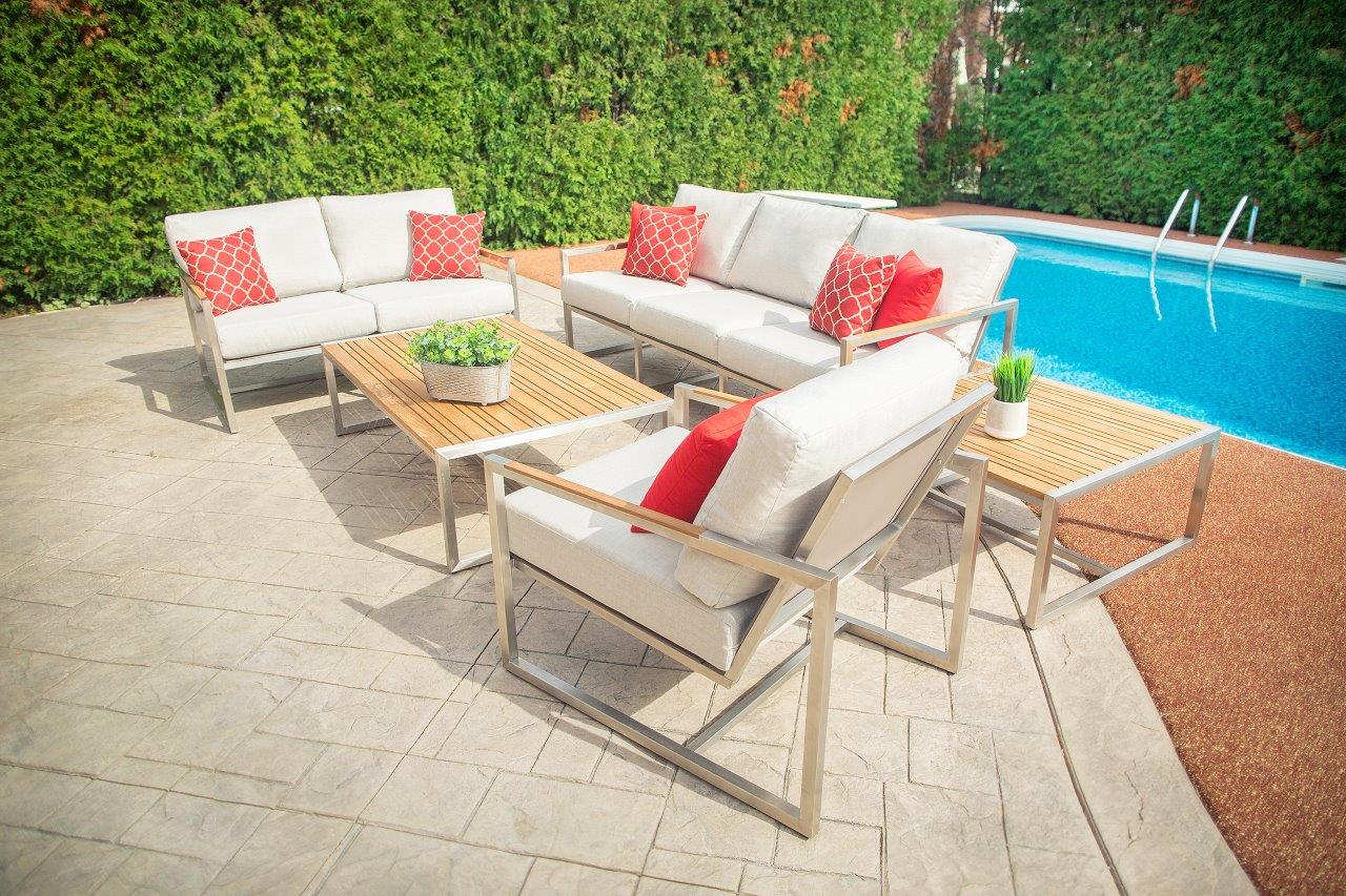 Outdoor scene with an Acacia coffee table surrounded by sofas, placed by the poolside, showcasing a modern and relaxing setup.